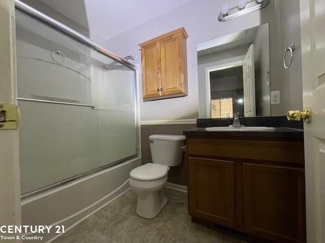 full bathroom with toilet, bath / shower combo with glass door, and vanity