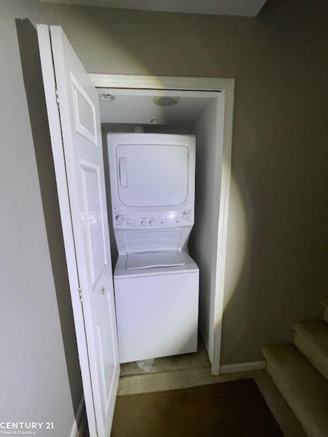 washroom featuring stacked washer / drying machine