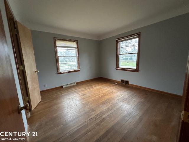 unfurnished room with hardwood / wood-style floors