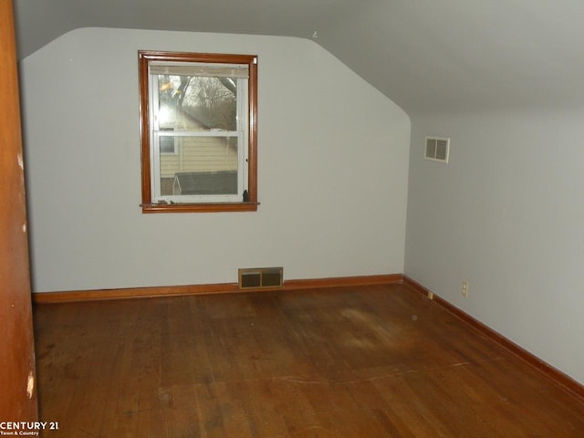 additional living space featuring dark hardwood / wood-style floors and lofted ceiling