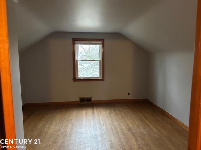 bonus room with lofted ceiling and hardwood / wood-style flooring