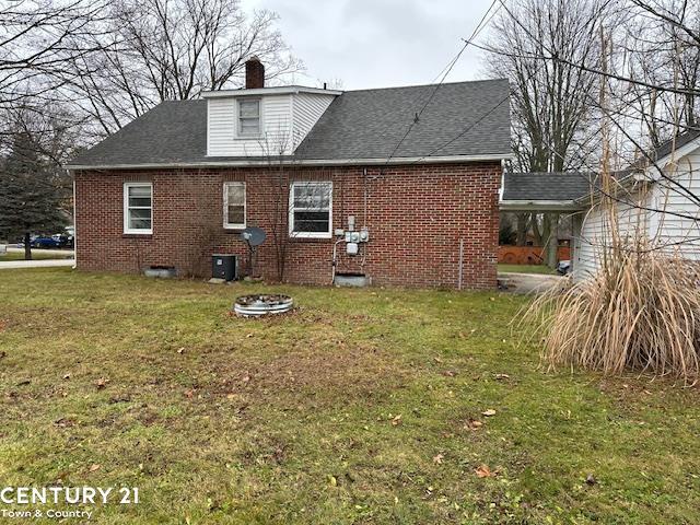 rear view of house featuring a lawn