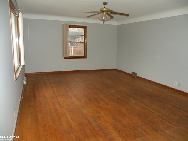 unfurnished room with ceiling fan and dark wood-type flooring