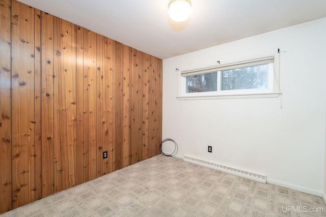 empty room with light carpet, a baseboard radiator, and wood walls