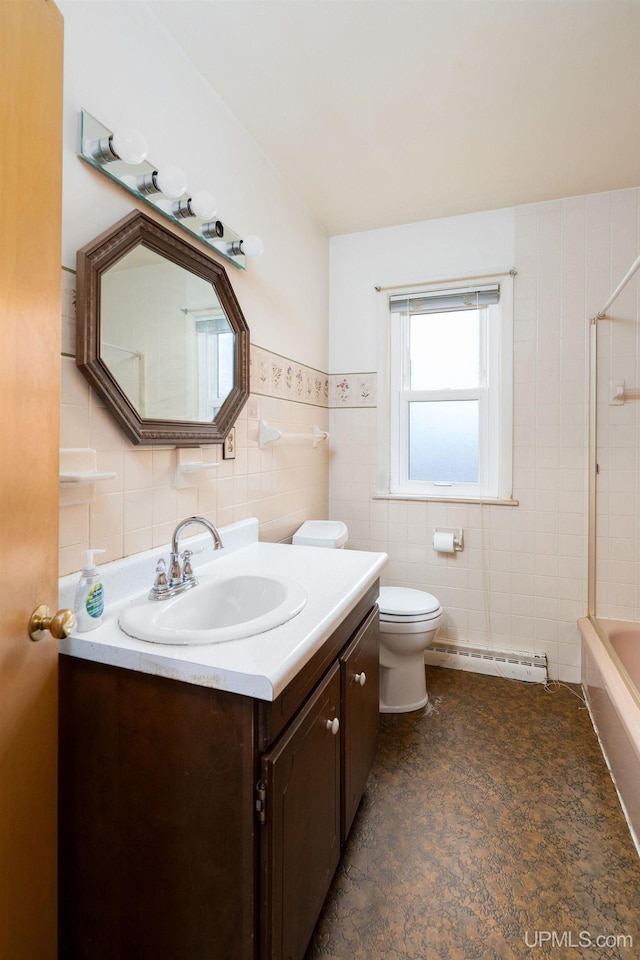 full bathroom with vanity, a baseboard heating unit, toilet, tile walls, and shower / bathtub combination