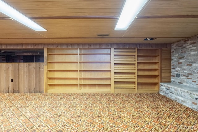 basement with built in shelves, wooden walls, and wood ceiling