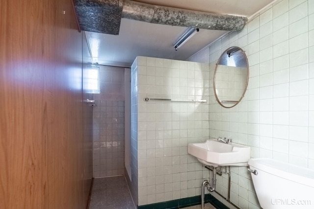 bathroom with sink, toilet, and tile walls