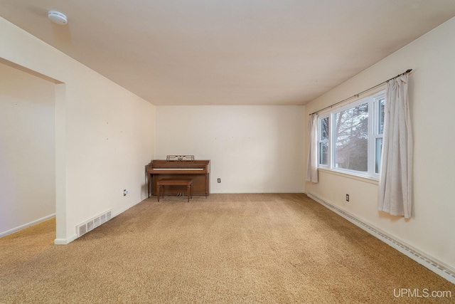 empty room featuring light colored carpet and a baseboard radiator