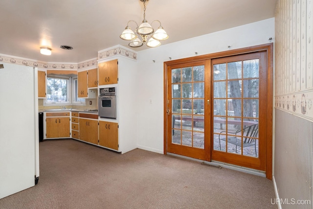 kitchen with light carpet, oven, a notable chandelier, and sink