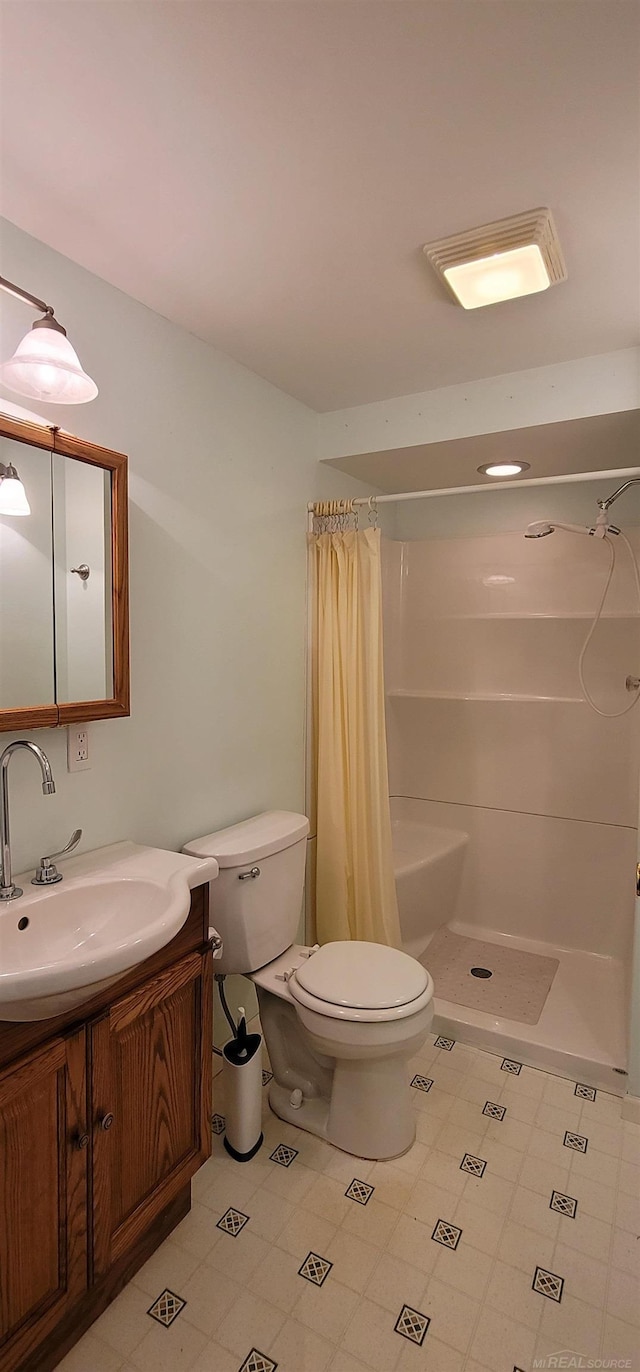 bathroom featuring vanity, curtained shower, and toilet