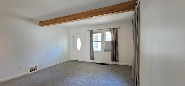 foyer with light carpet and beamed ceiling