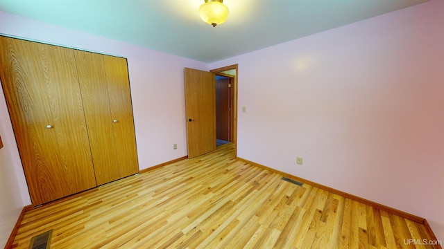 unfurnished bedroom featuring a closet and light hardwood / wood-style floors