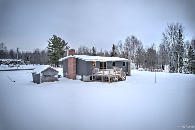 snow covered rear of property featuring a deck