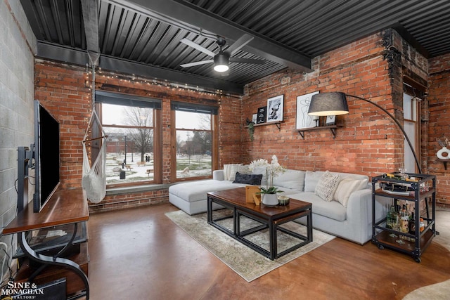 living room with ceiling fan, concrete floors, and brick wall