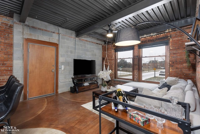 living room with beam ceiling, brick wall, and concrete floors