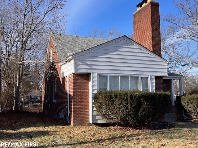 view of side of home with a lawn