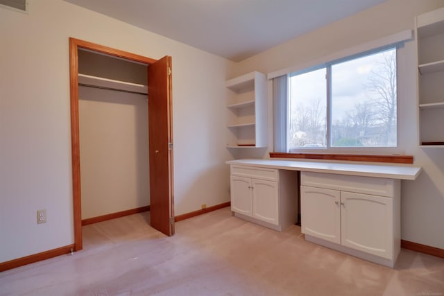 unfurnished office with built in desk and light colored carpet