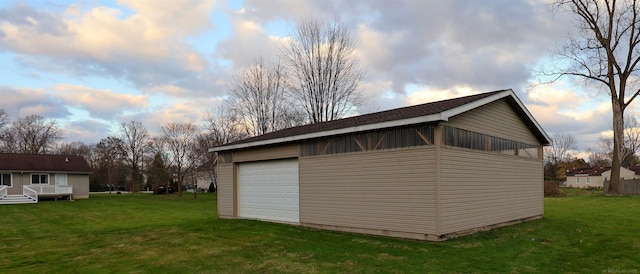 outdoor structure at dusk with a lawn and a garage