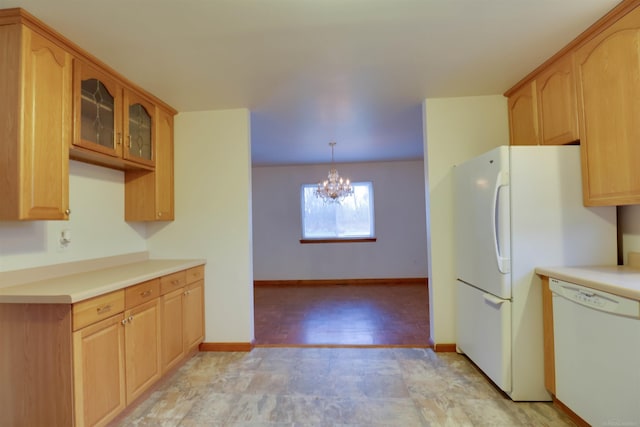 kitchen with decorative light fixtures, white appliances, and an inviting chandelier