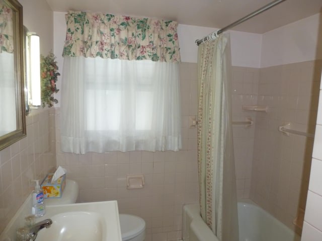 full bathroom with sink, a healthy amount of sunlight, tile walls, and toilet