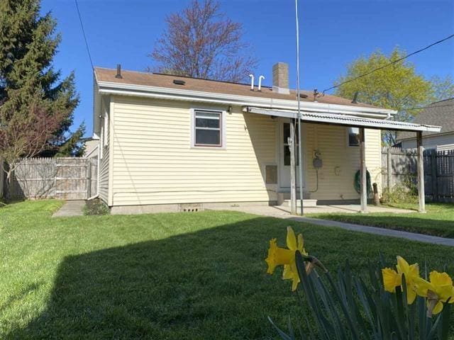 rear view of property with a lawn