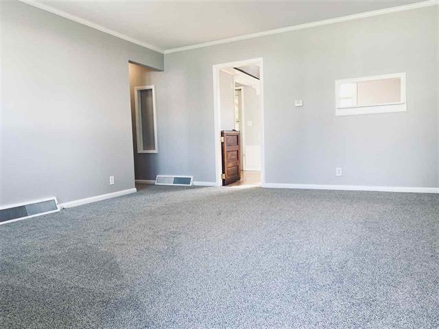 carpeted spare room featuring ornamental molding