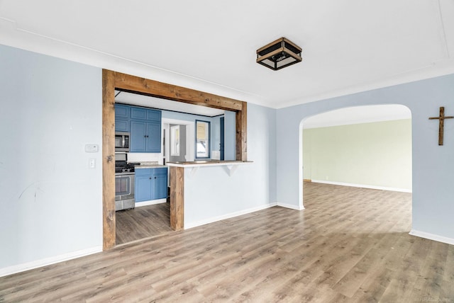 unfurnished living room featuring crown molding and light wood-type flooring