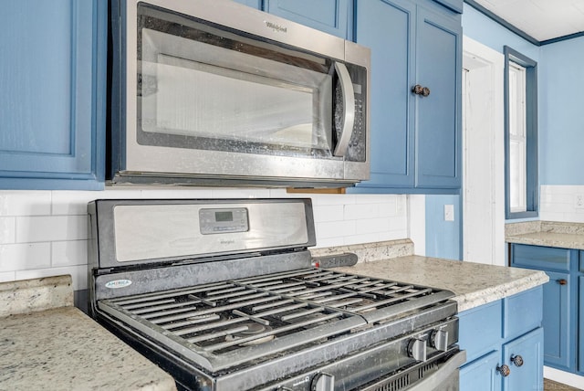 details with black stove, tasteful backsplash, blue cabinets, and light stone counters