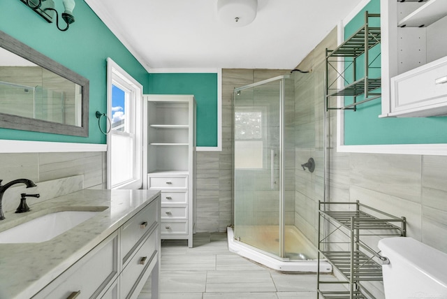 bathroom with tile walls, vanity, and an enclosed shower