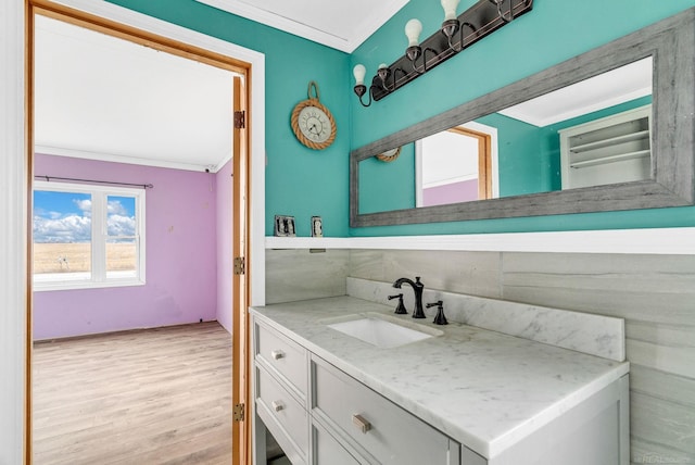 bathroom with crown molding, hardwood / wood-style floors, and vanity