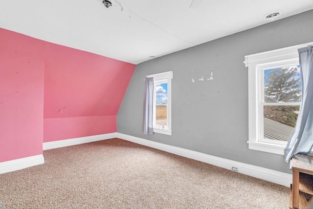 bonus room with carpet flooring and vaulted ceiling