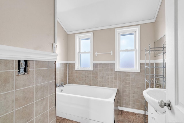 bathroom featuring vanity, tile patterned floors, tile walls, and a bathing tub