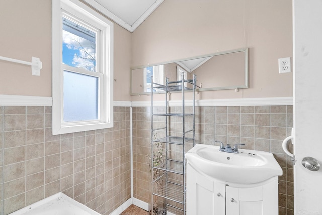 bathroom featuring vanity, crown molding, and tile walls