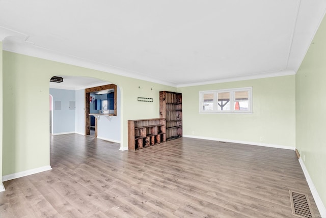 unfurnished living room with hardwood / wood-style flooring and ornamental molding