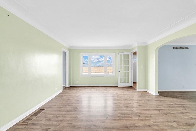 empty room featuring light hardwood / wood-style floors and crown molding