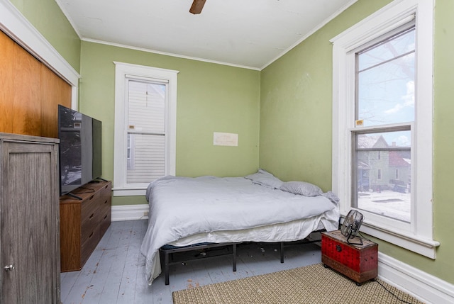 bedroom with ceiling fan, a closet, light wood-type flooring, and ornamental molding