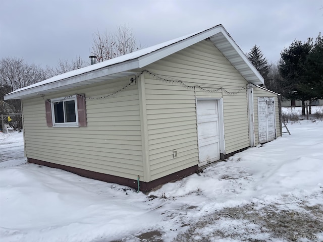 snow covered structure with a garage