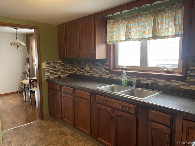 kitchen featuring pendant lighting, backsplash, and sink