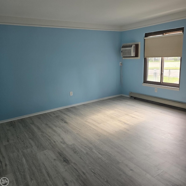 30442 Utica Rd, Roseville, MI 48066 - empty room featuring an AC wall unit, a baseboard radiator, and wood-type flooring