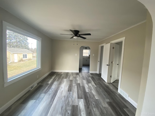 spare room with ceiling fan, dark hardwood / wood-style flooring, and ornamental molding