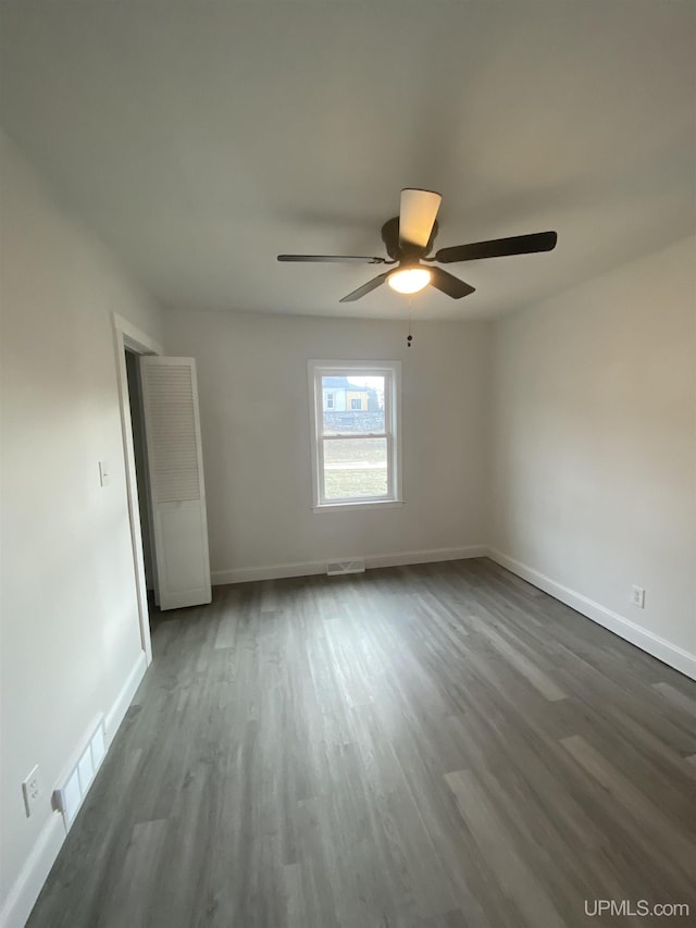 spare room with ceiling fan and dark wood-type flooring