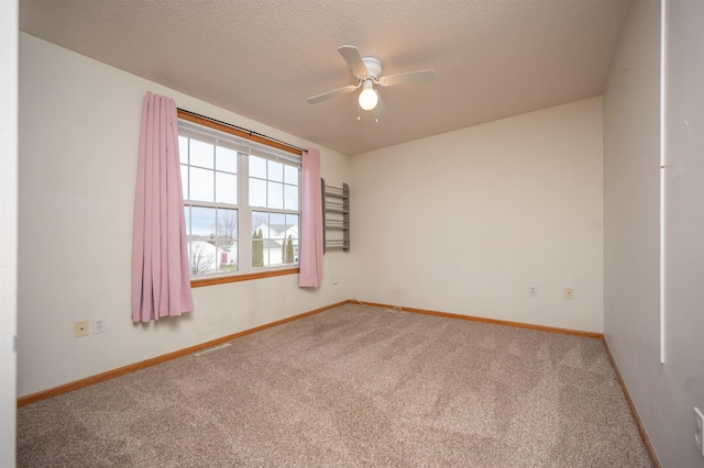 unfurnished room featuring a textured ceiling, carpet floors, and ceiling fan