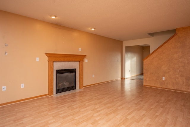 unfurnished living room featuring light wood-type flooring and a fireplace