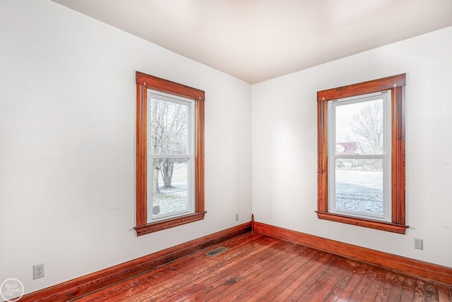 unfurnished room with hardwood / wood-style flooring and a healthy amount of sunlight