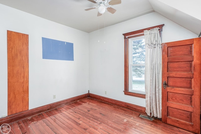 empty room with ceiling fan, vaulted ceiling, and hardwood / wood-style flooring