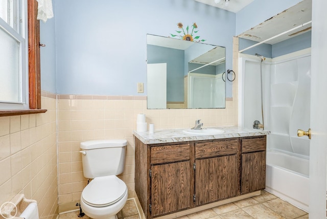 full bathroom with vanity, bathtub / shower combination, tile patterned floors, toilet, and tile walls