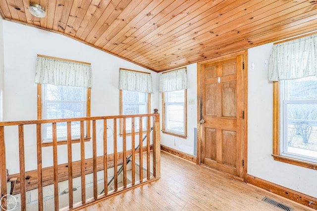 hall with lofted ceiling, wood ceiling, and a wealth of natural light