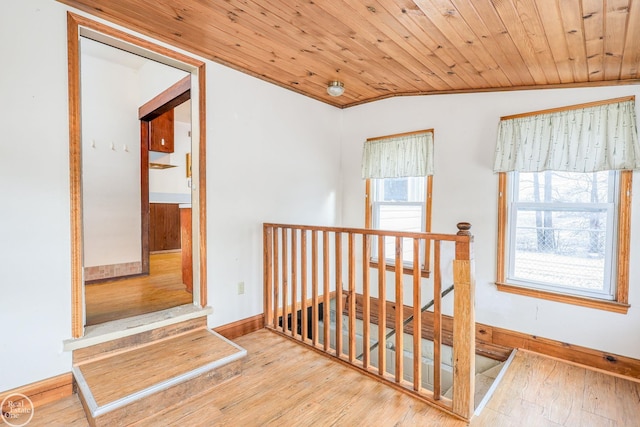 hallway featuring vaulted ceiling, wooden ceiling, and light hardwood / wood-style flooring