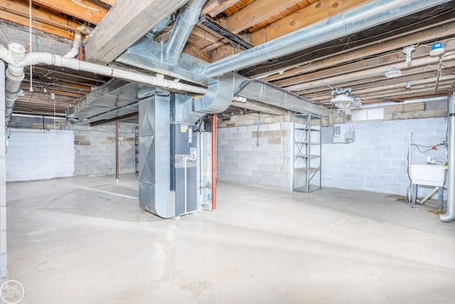 basement with heating unit, water heater, and sink