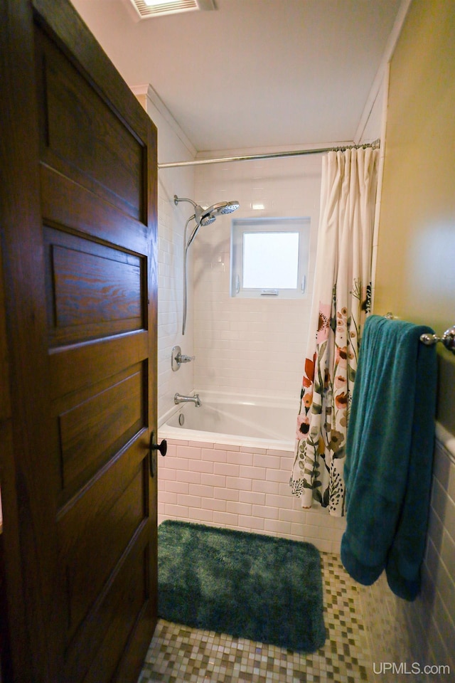 bathroom with shower / bath combo with shower curtain and ornamental molding